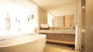 Ein modernes Badezimmer mit einer großen Badewanne, einer Duschkabine aus Glas und einem Waschtisch mit Spiegel.