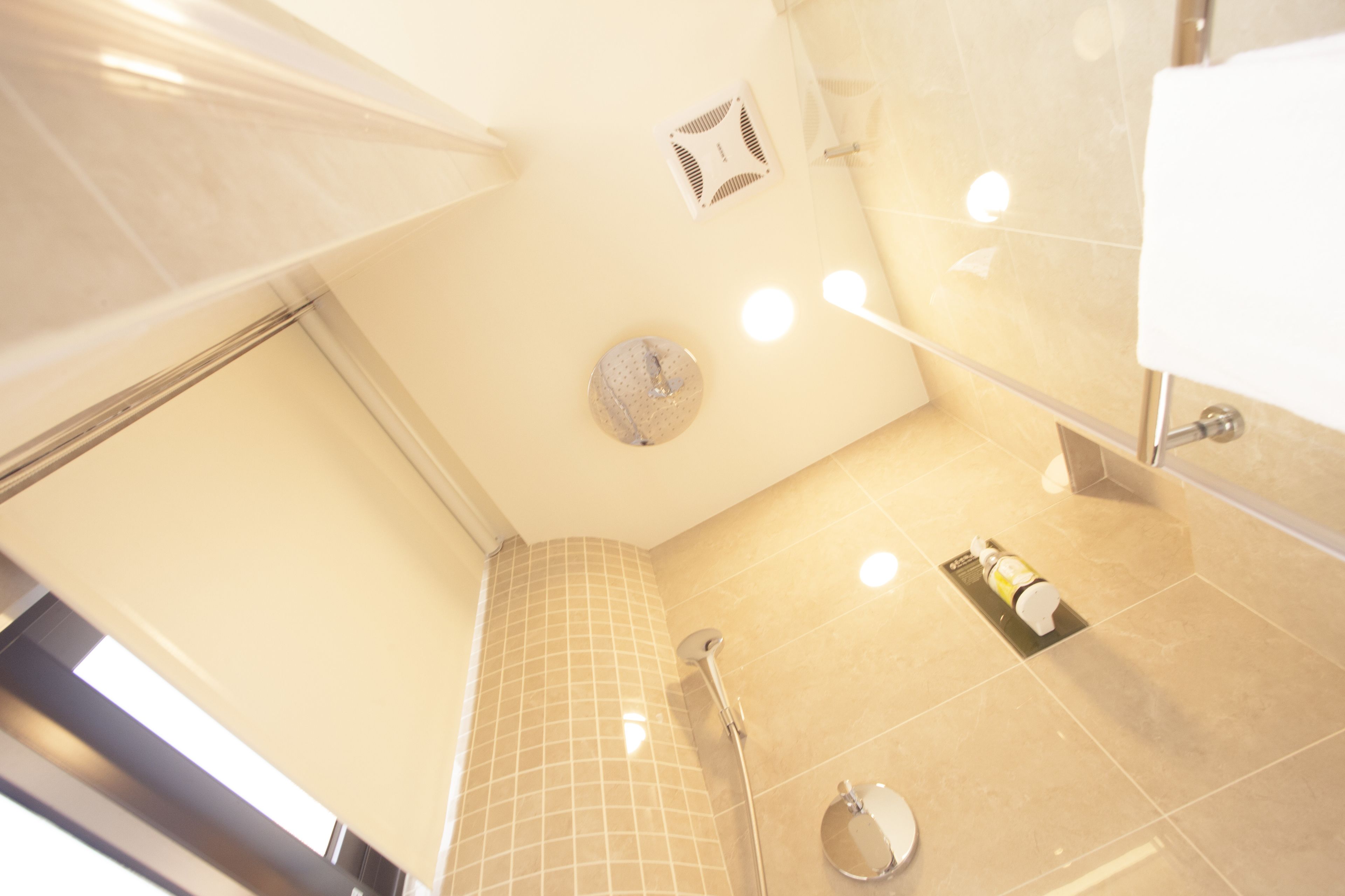 A modern bathroom with a shower, a toilet, and a sink.