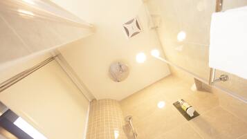 A modern bathroom with a shower, a toilet, and a sink.