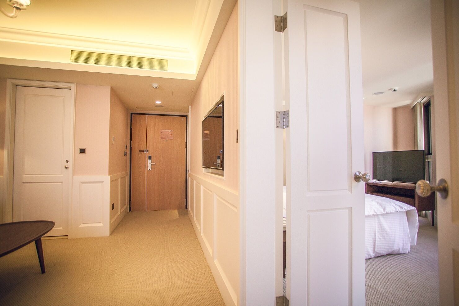A hotel room with a bed, a TV, a desk, and a chair.