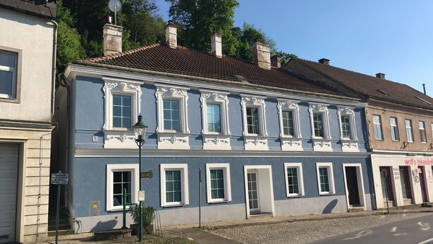 A historic building with a blue facade, multiple windows, and a cobblestone street. - Alte Post Greifenstein (Sankt Andrae-Woerdern)
