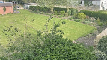 A well-maintained garden with a lawn, various shrubs, and trees.