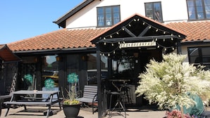 A building with a sign reading "BED & BREAKFAST" and a patio area with tables and chairs. - The Crown Lodge Bar Bed & Breakfast  (Lincoln)