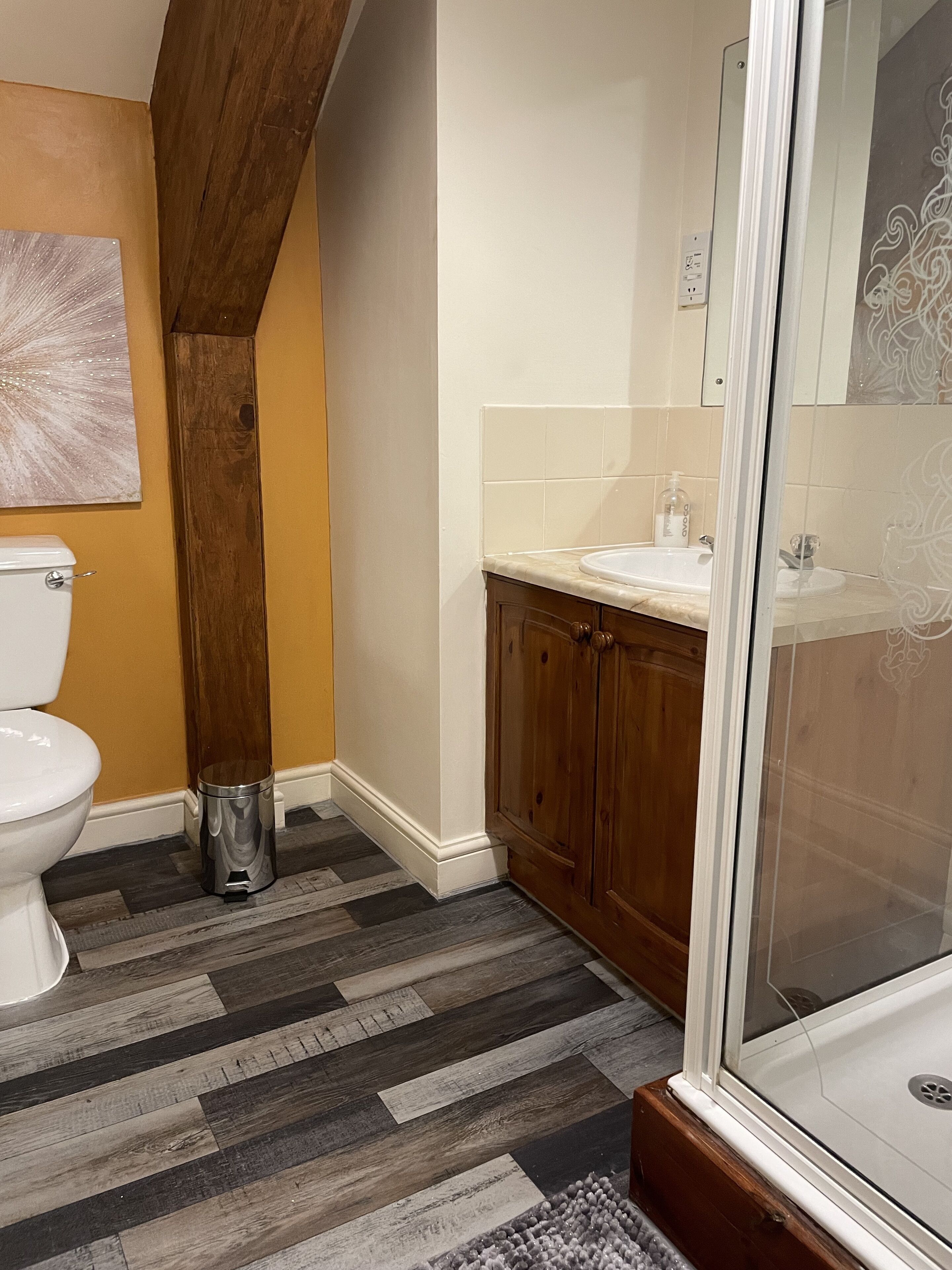 A bathroom with a toilet, sink, and shower.