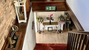 A staircase with a fire exit sign, a vintage sewing machine, and decorative plants. - The Crown Lodge Bar Bed & Breakfast  (Lincoln)