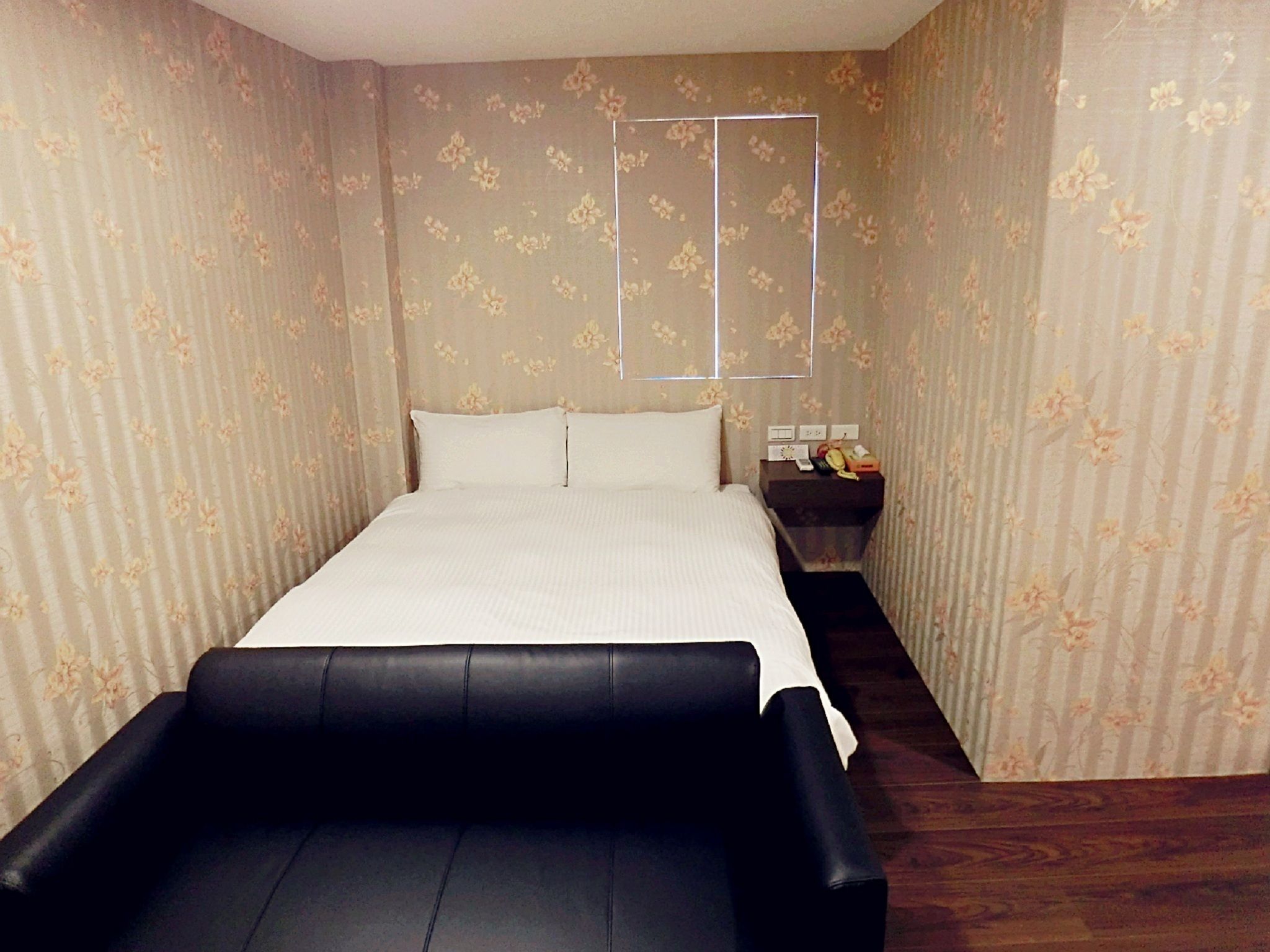 Ein Schlafzimmer mit einem Bett, einem Nachttisch und einem kleinen Tisch.