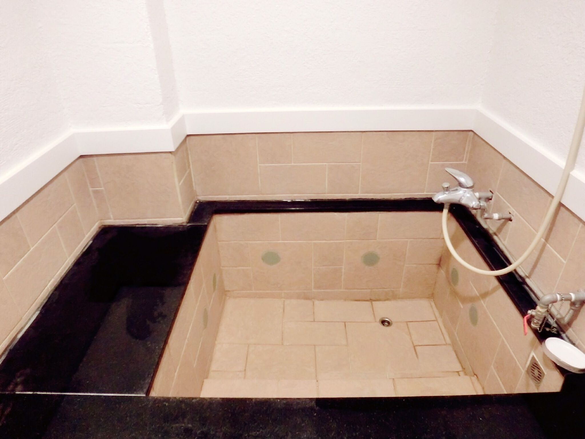 A corner bathroom with a bathtub, a shower, and a toilet.