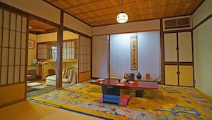Une pièce de style japonais traditionnel, avec un sol recouvert de tatamis, une table basse et des portes coulissantes.