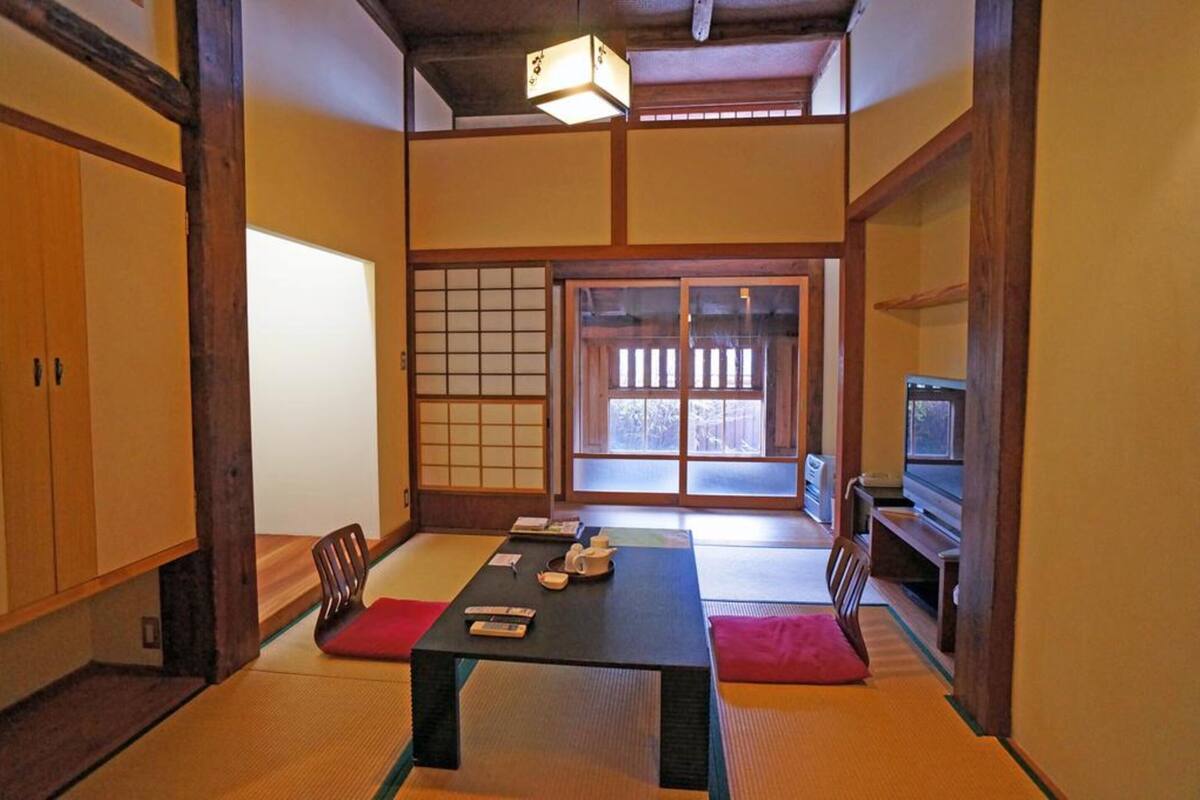 A traditional Japanese room with tatami flooring, a low table, and sliding doors.