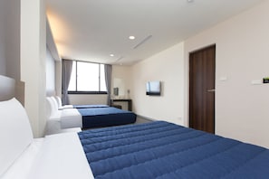 A hotel room with two beds, a TV, a desk, and a window with curtains. - Bulowan Hotel (Hualien City)