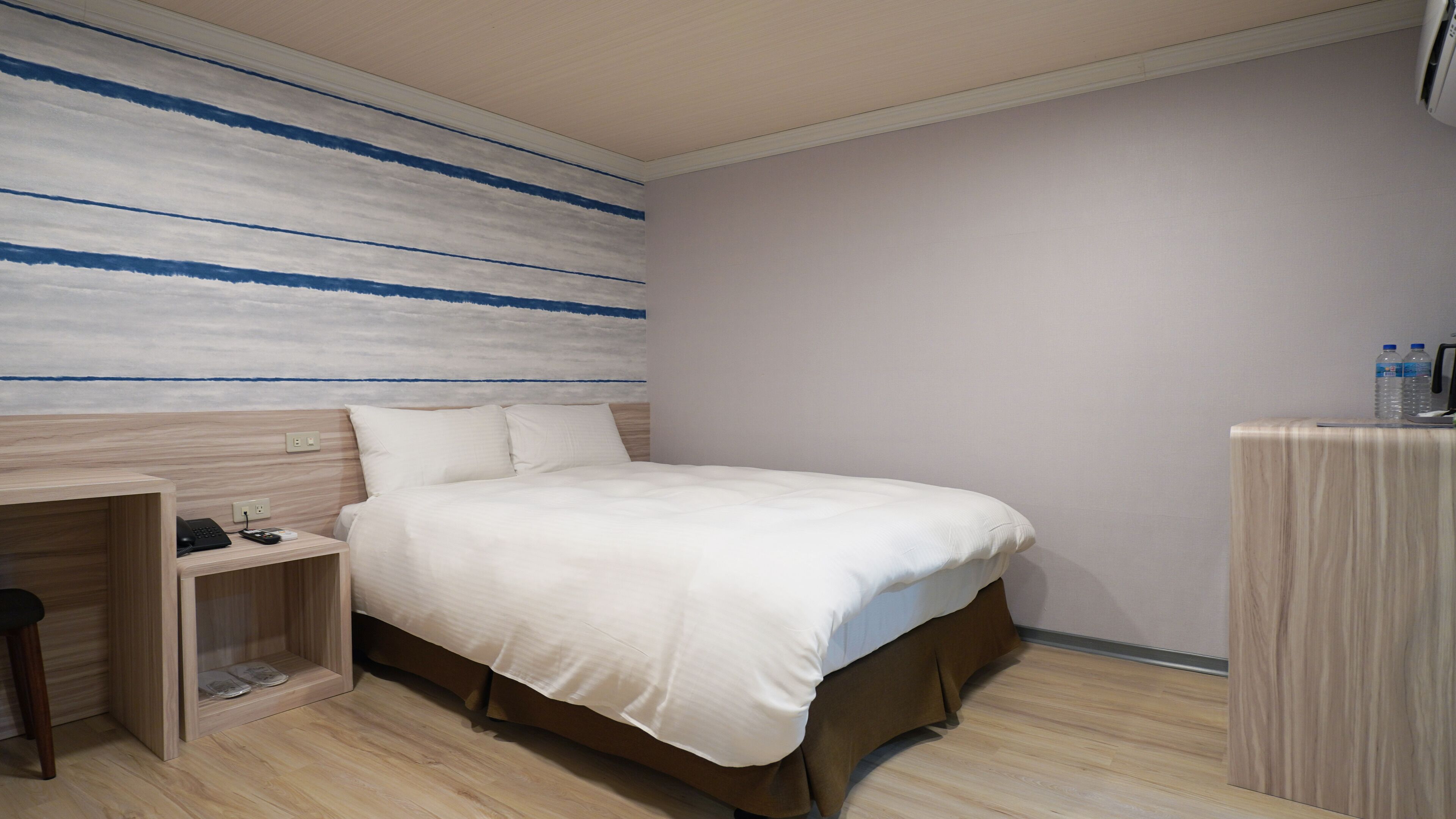 Una habitación de hotel con cama, escritorio y armario.