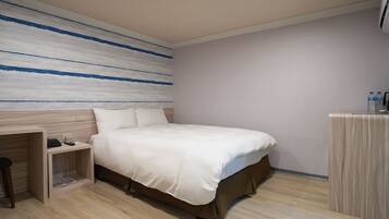 Una habitación de hotel con cama, escritorio y armario.