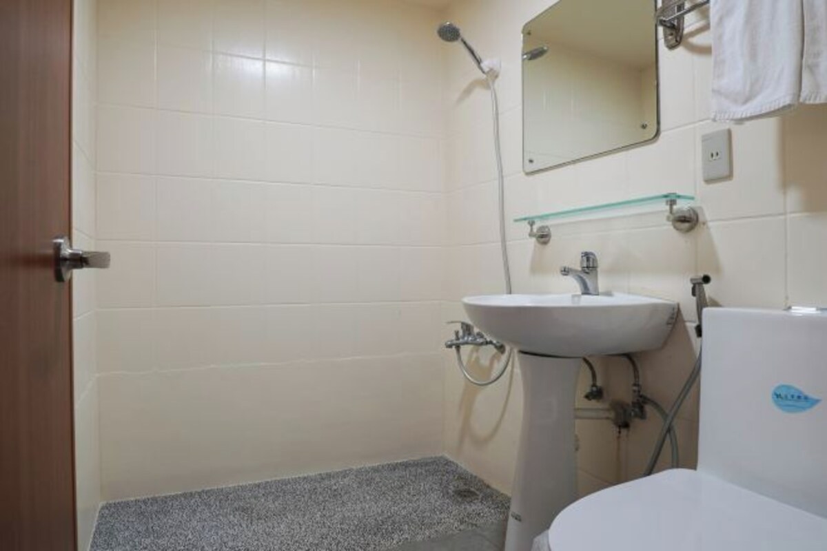 A bathroom with a white sink, a mirror, and a shower.