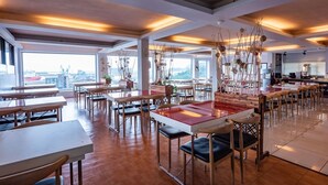 Un restaurante espacioso con techos altos, iluminación moderna y vistas a la ciudad.