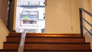 Una escalera de madera con barandillas metálicas que conduce a un espacio al aire libre.