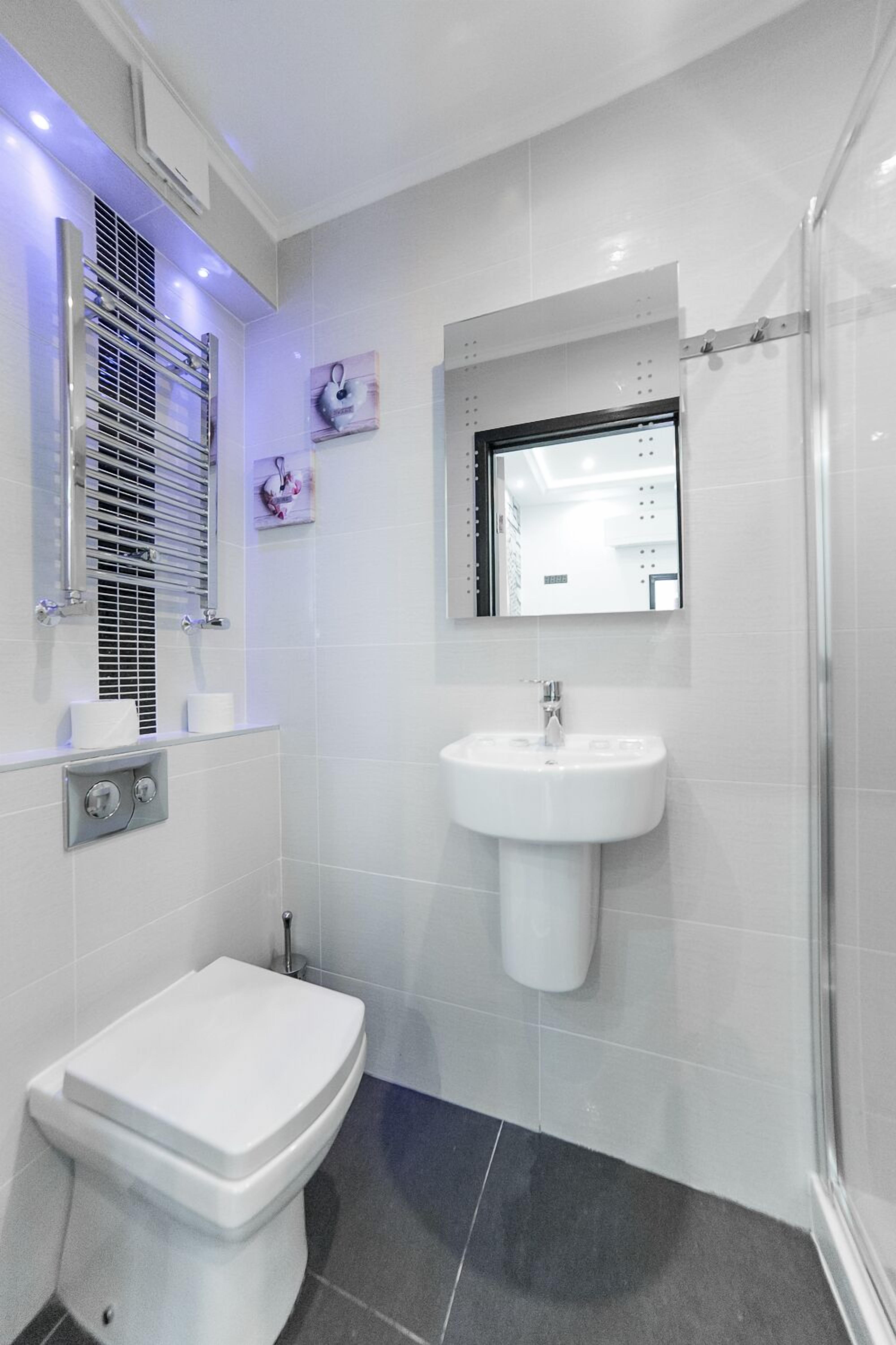 Une salle de bain moderne équipée de toilettes, d’un lavabo et d’une douche.