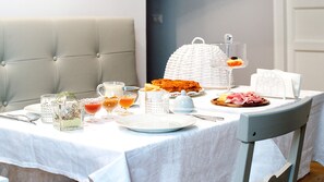 A breakfast table set with plates, glasses, and a variety of food items. - La Piazzetta Rooms (Genoa)