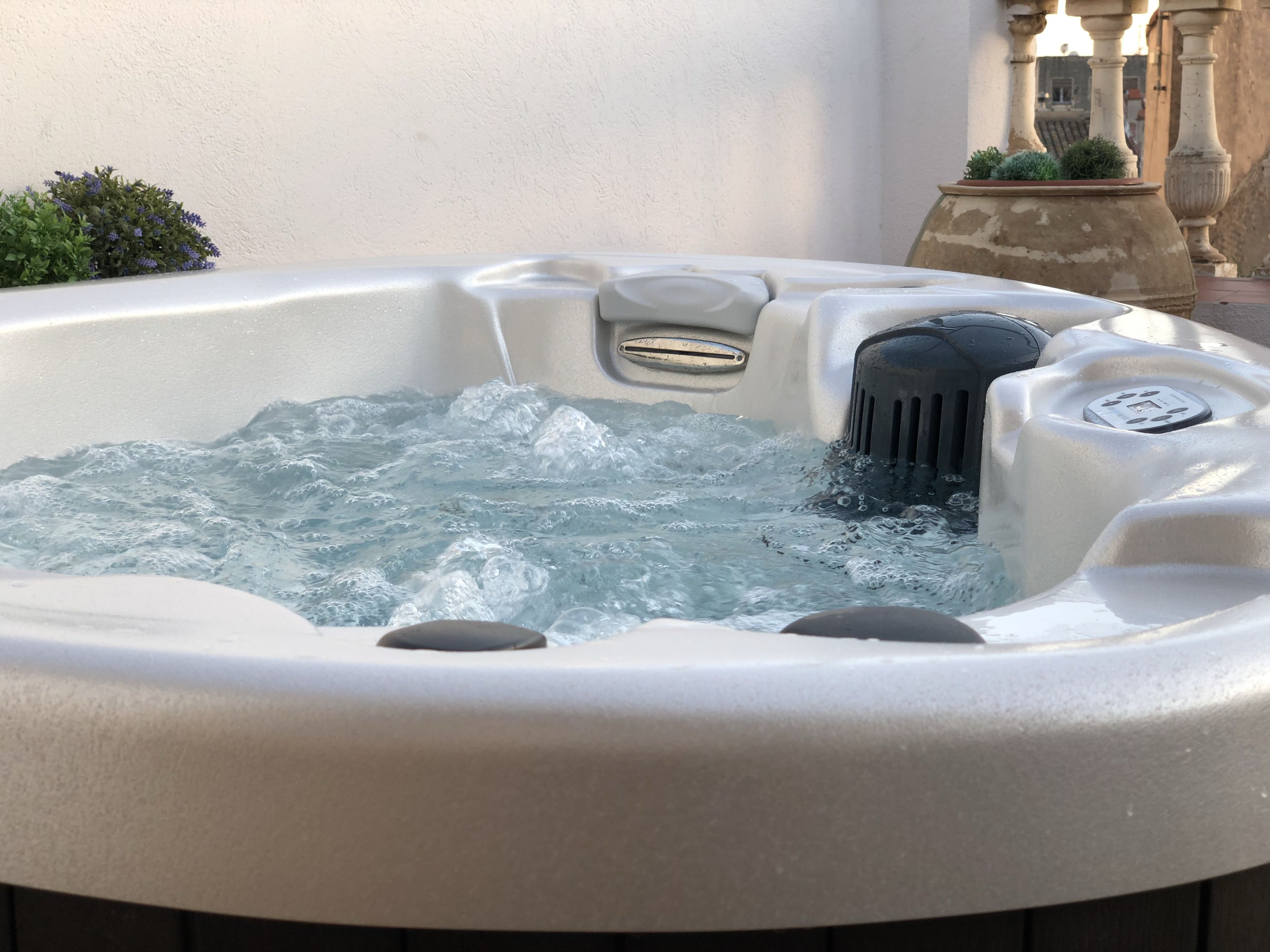 Un jacuzzi con agua, un panel de control y un elemento decorativo de piedra.