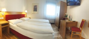 A hotel room with two beds, a desk, a chair, a TV, and a window with curtains. - Hotel Weinhaus Selmigkeit (Bingen am Rhein)