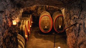 A cellar with wooden barrels, stone walls, and candles providing light. - Hotel Weinhaus Selmigkeit (Bingen am Rhein)