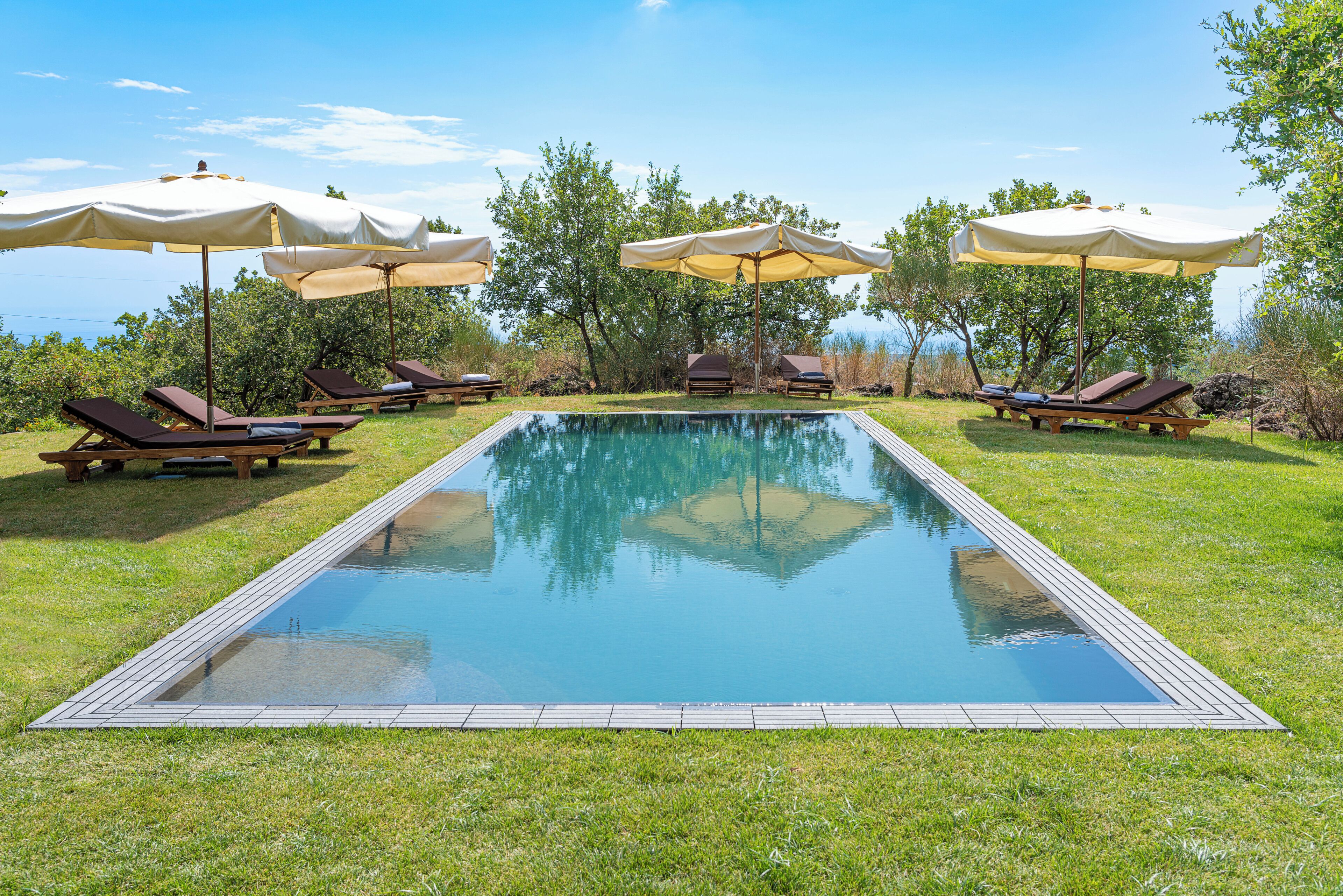 Una piscina al aire libre, tumbonas