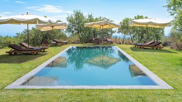 Una piscina al aire libre, tumbonas