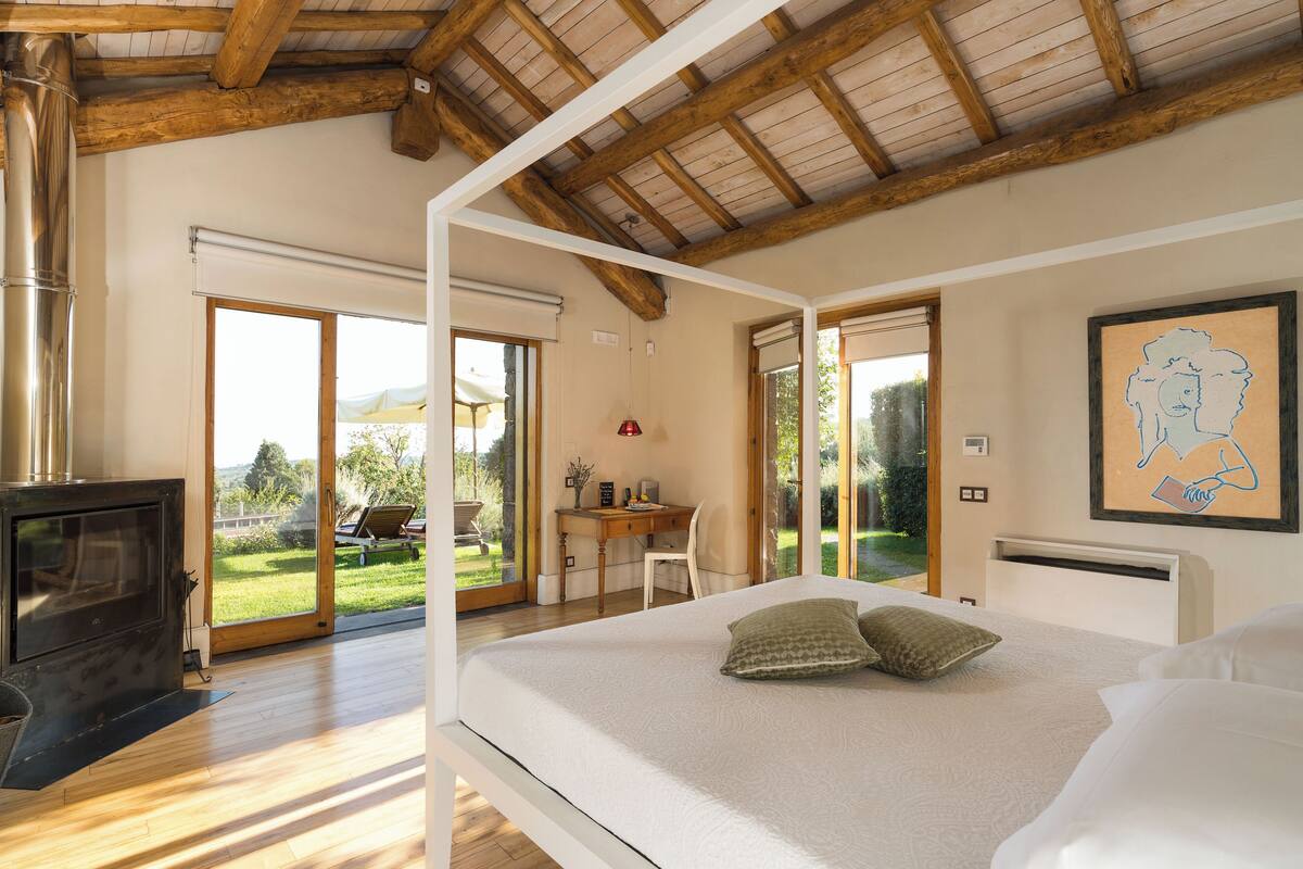 Une chambre à coucher avec un lit, un bureau et une vue sur l’extérieur.
