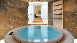 Un jacuzzi con vista despejada a una habitación con cama y un cuadro en la pared.