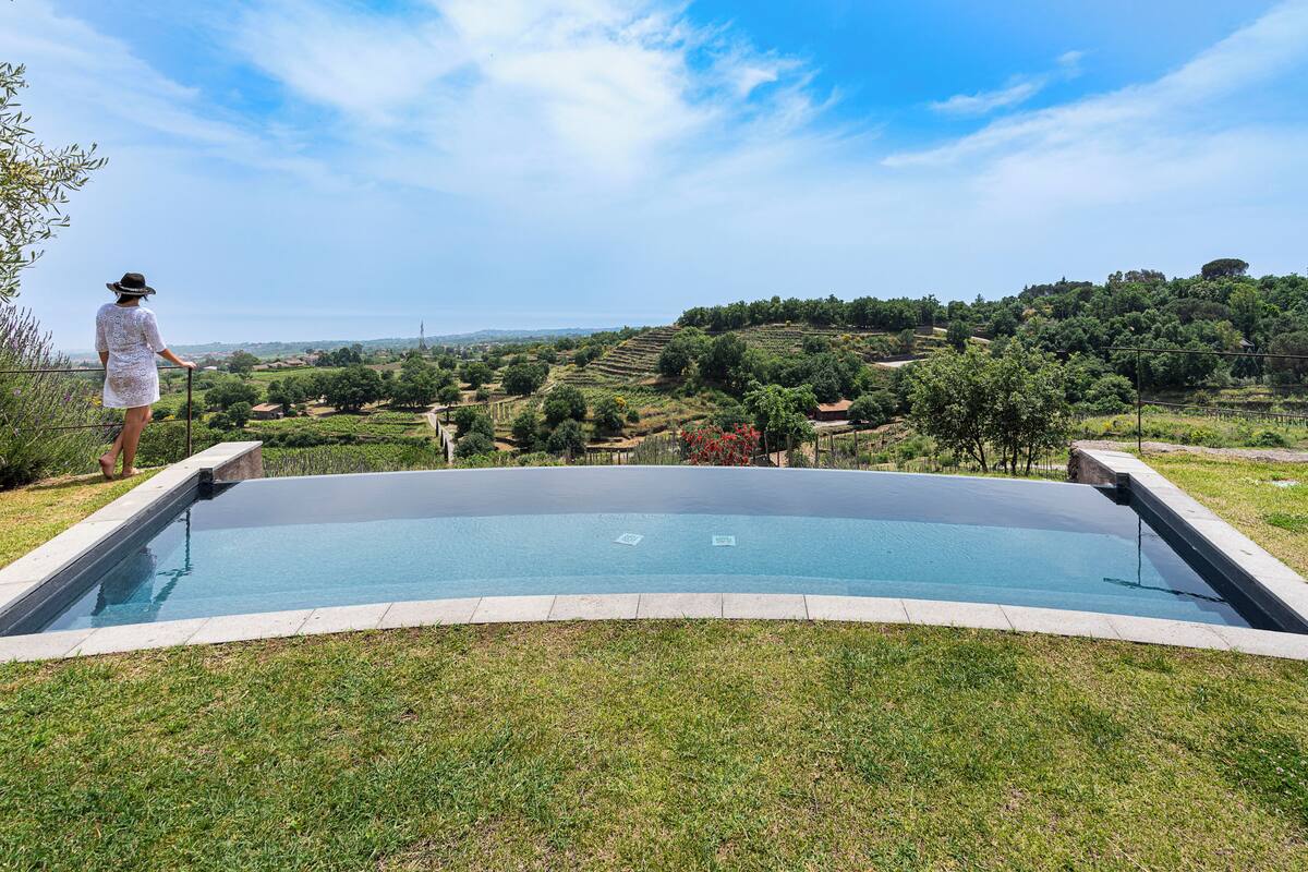Une piscine avec vue sur un paysage vallonné.