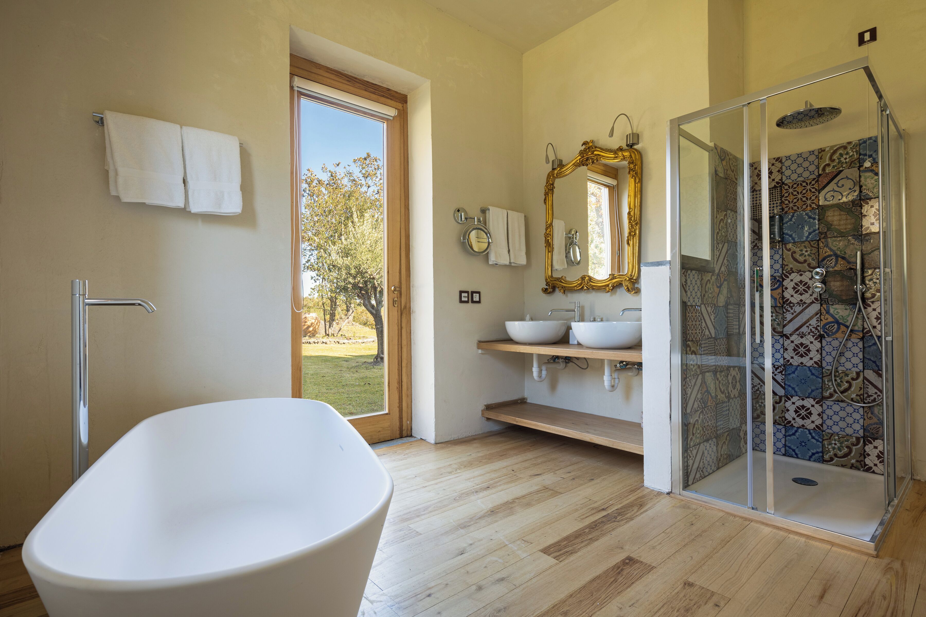 Une salle de bain moderne avec une baignoire sur pieds, une douche à parois de verre et un grand miroir.