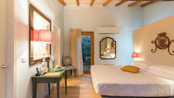 Une chambre à coucher avec un lit, un bureau avec une lampe, une chaise et un miroir.