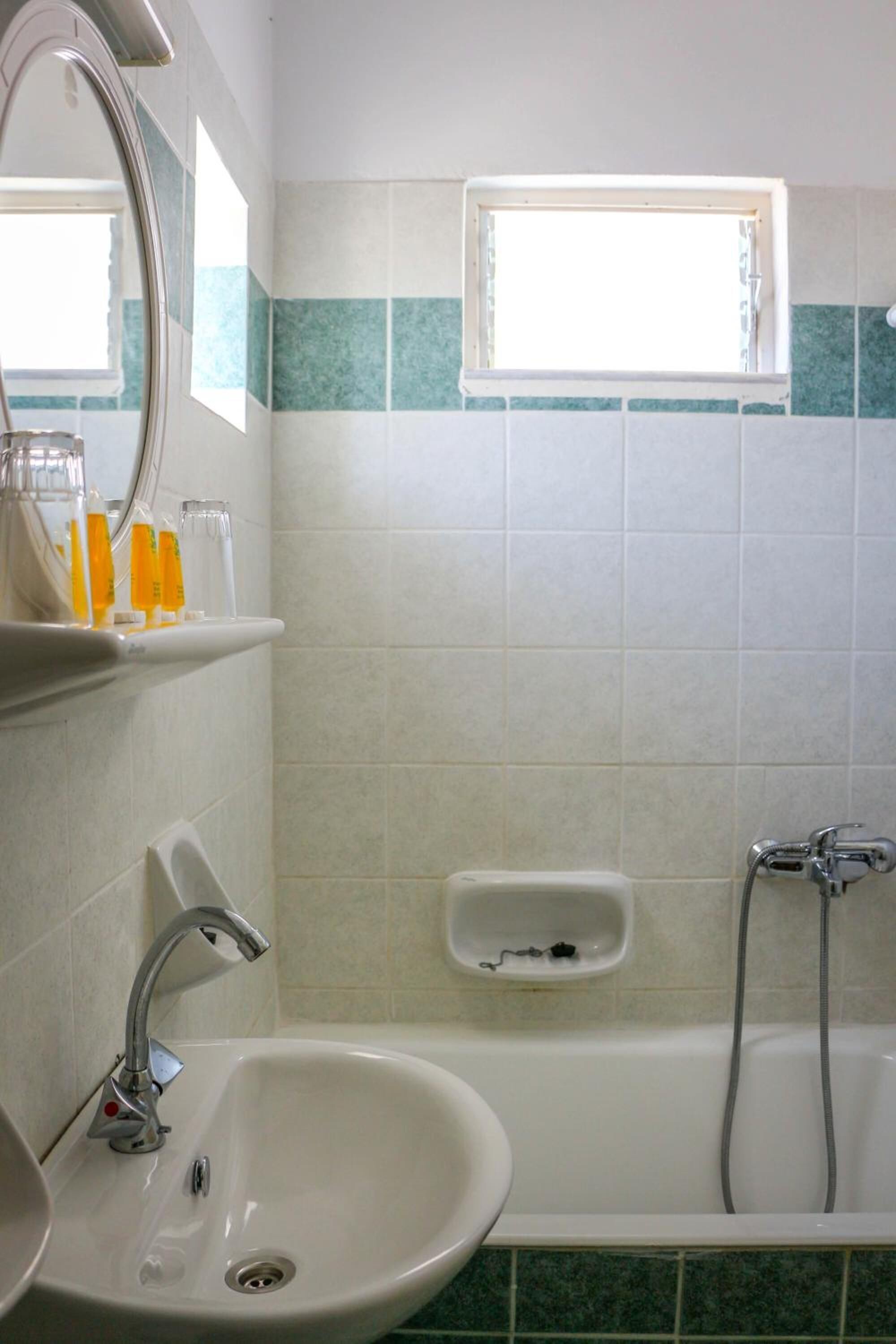 Un baño con lavamanos, espejo y bañera.