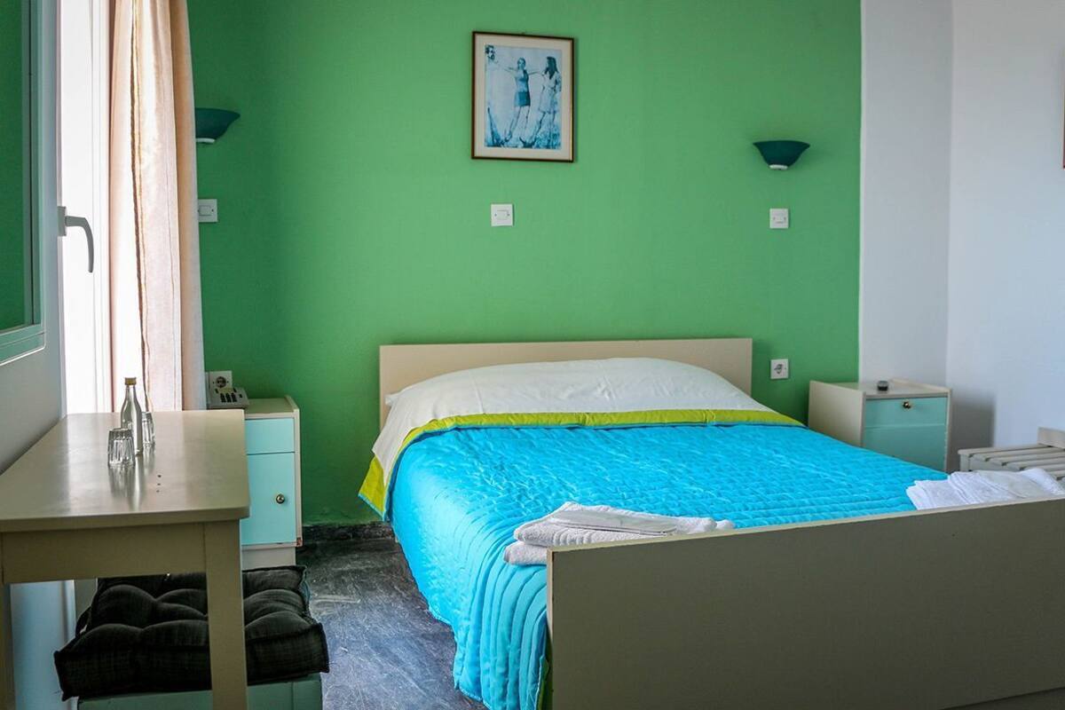 A bedroom with a bed, bedside tables, a desk, and a chair.