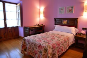Un dormitorio con cama, escritorio y silla.