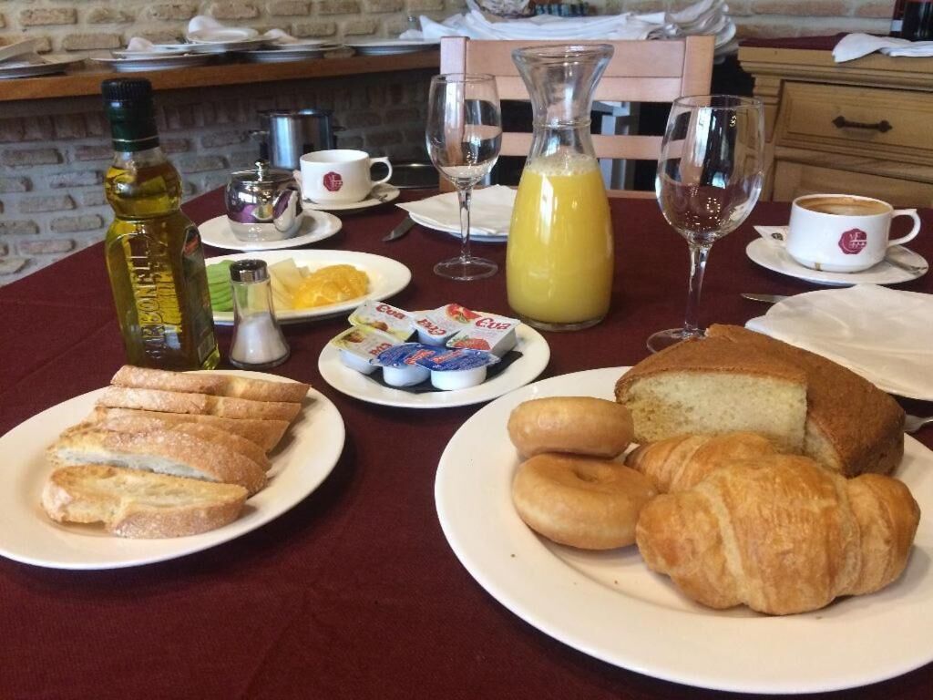 Ett frukostbord med bröd, croissanter, juice och kaffe.