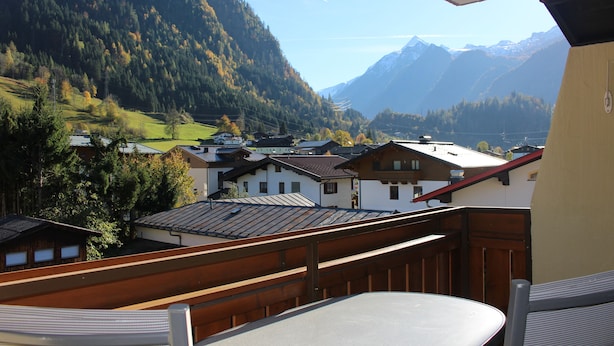 Ein Balkon mit Blick auf eine gebirgige Landschaft, einschließlich Häuser und einem Tal.