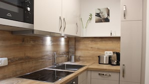 Eine moderne Küche mit Edelstahlgeräten, Holz Arbeitsplatten und einem eingebauten Ofen.
