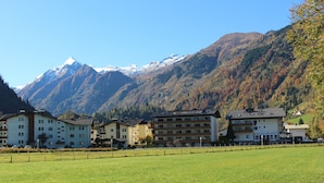 Ein Hotel mit mehreren Stockwerken vor einer Bergkulisse.