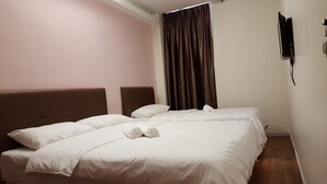 Een hotelkamer met twee bedden, een hoofdbord, een gordijn en een aan de muur bevestigde telefoon.