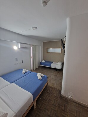 Habitació triple econòmica, bany privat | Caixa forta a l'habitació, mobiliari individual i cortines opaques