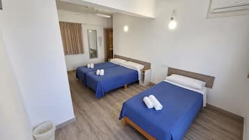 Chambre triple Deluxe, salle de bain privée | Coffre-fort, ameublement unique, rideaux d’obscurcissement