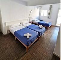 Habitación triple Deluxe, baño privado | Caja fuerte, mobiliario individual, cortinas opacas y wifi gratis