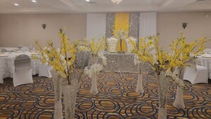 A banquet hall with tables set for a formal event, featuring decorative vases with flowers and a chandelier. - Days Inn and Suites by Wyndham Oxford (Oxford)