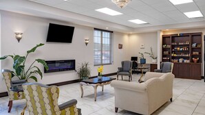 A spacious lobby with a flat-screen TV, comfortable seating, a coffee table, and a bookshelf. - Days Inn and Suites by Wyndham Oxford (Oxford)