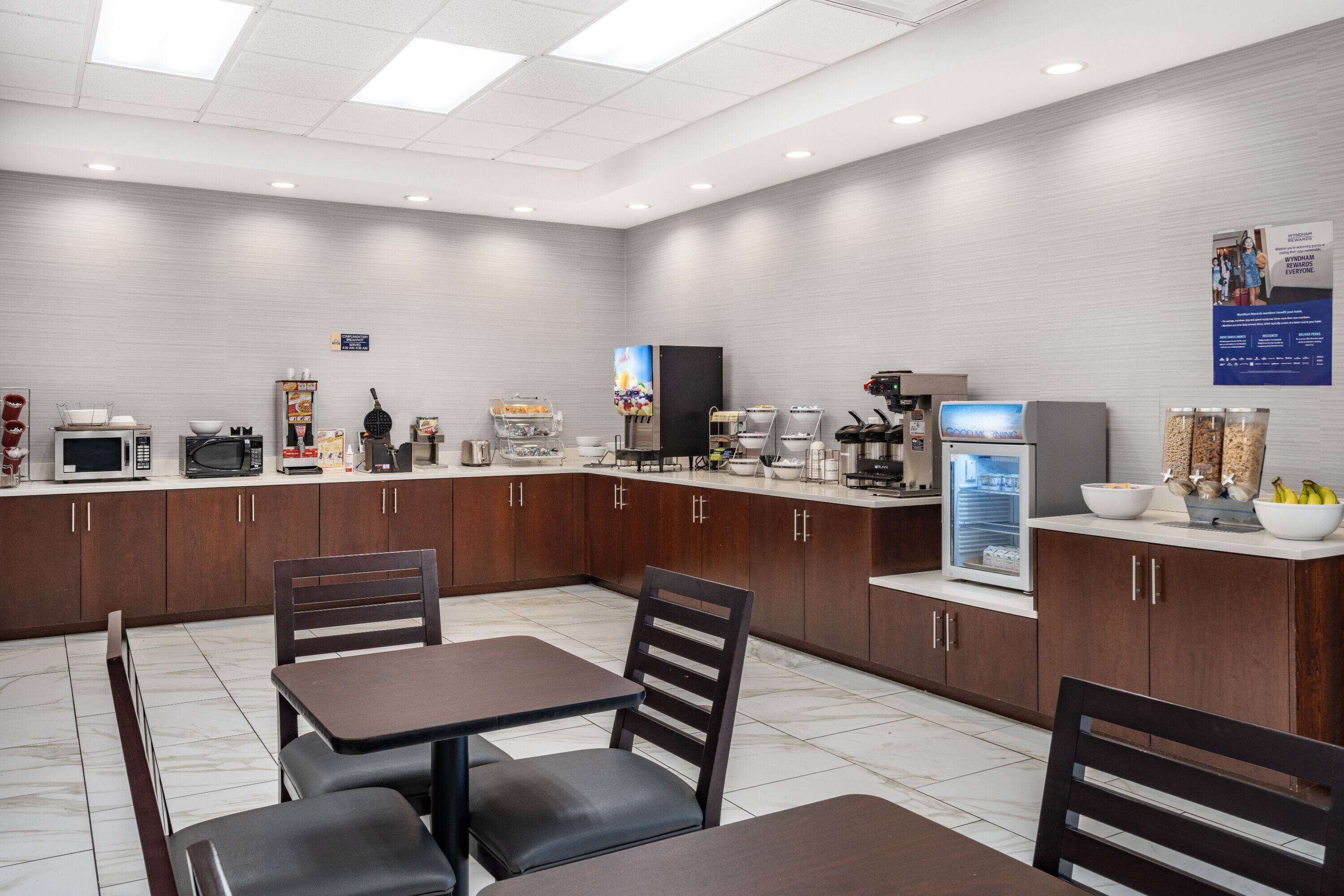 A modern kitchen with a dining area, equipped with appliances like a microwave, toaster, and coffee maker.