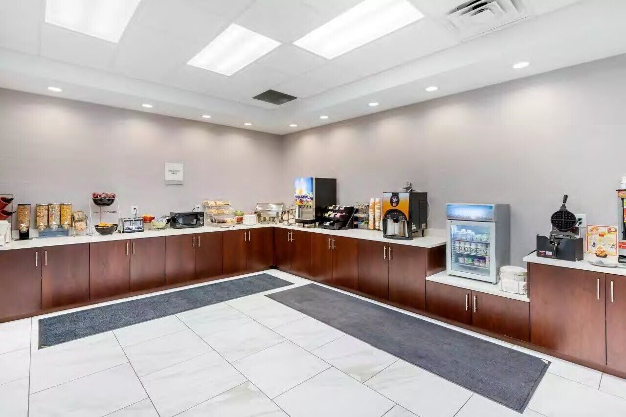 Un área de cocina moderna con una isla central, equipada con diversos electrodomésticos y un refrigerador.