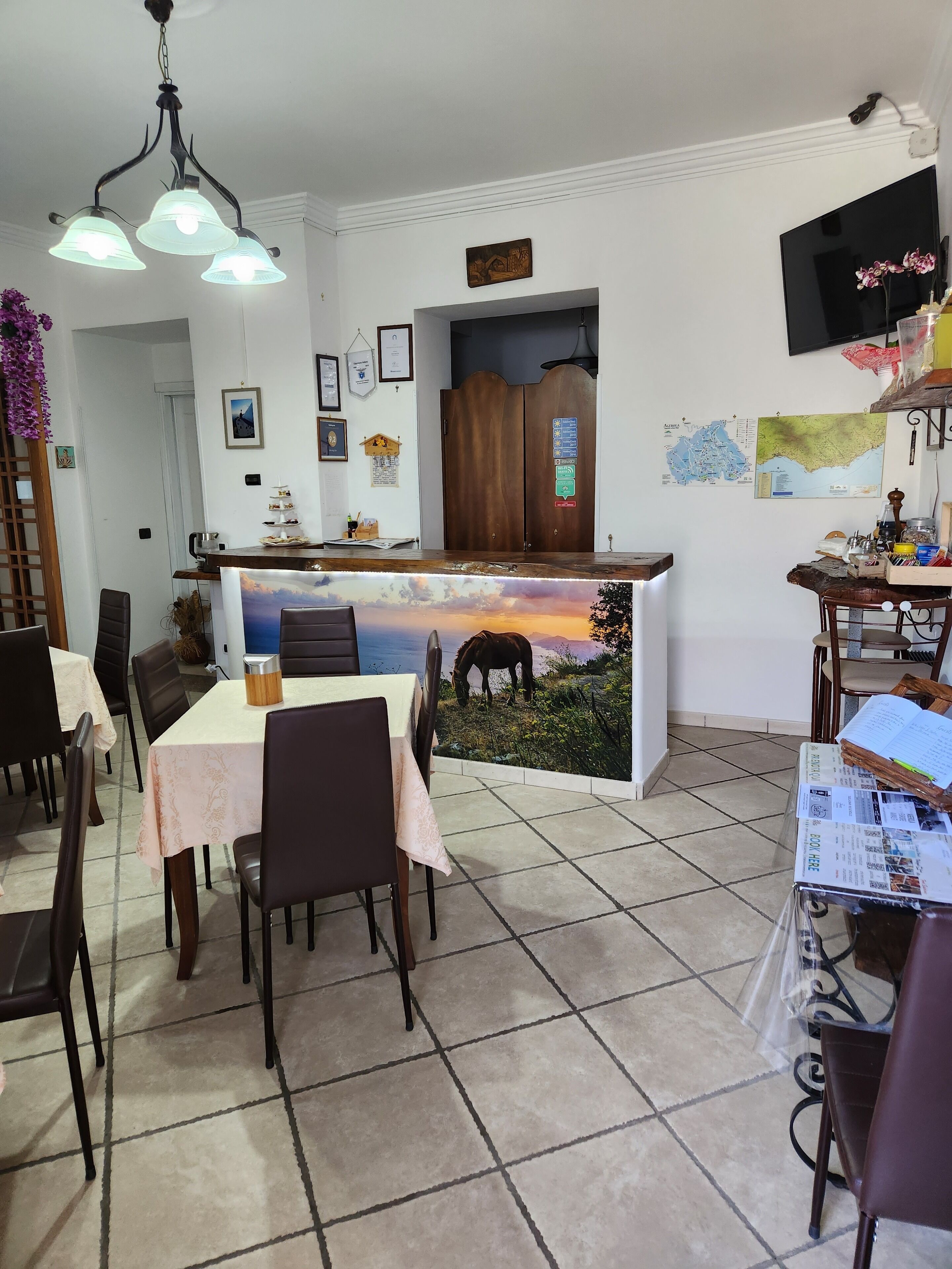 A dining area with a table set for four, a wooden cabinet, and a map on the wall.