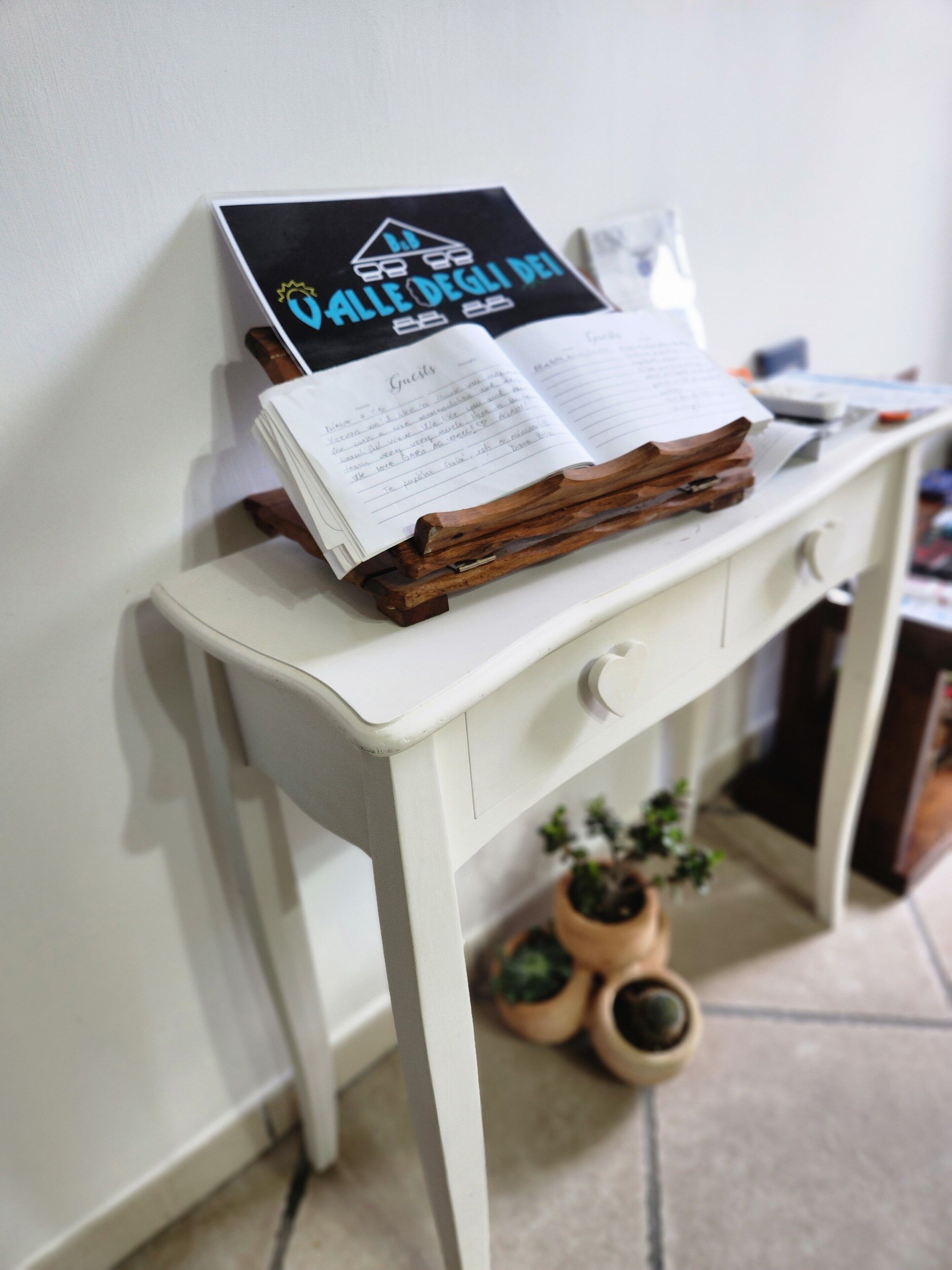 A white desk with a book and a sign on it.