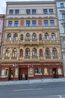 A multi-story building with a ground-floor restaurant, a visible hotel sign, and a café.