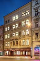 A historic building with multiple floors, featuring a ground-level restaurant, a café, and a hotel.